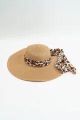 Sombrero de ala ancha confeccionado en fibra natural trenzada, con cinta decorativa de tela con estampado animal print de leopardo.