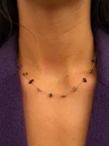 Collar delicado de cadena dorada con pequeñas piedras naturales en tonos variados, dispuestas de forma sutil a lo largo de la pieza.