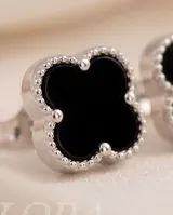 Caravanas de plata 925 con diseño de flor de cuatro pétalos en color negro.