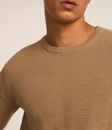 Suéter negro de tejido de punto maquinetado con cuello redondo y manga larga.