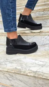 Zapatos de cuero estilo botineta baja en combinación de tonos marrones y beige, con suela chunky de plataforma plana y diseño texturizado en el talón.