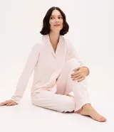 Pijama estilo americano compuesto por camisa de manga larga con cuello solapa, cierre frontal abotonado y pantalón largo con cintura elástica. Presenta bordado decorativo y detalles de ribetes en contraste.