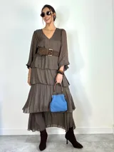 Vestido largo de seda italiana color chocolate, con escote en V, mangas largas abullonadas y diseño de falda con volados escalonados.