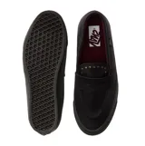 Championes Vans tipo mocasín de cuero negro, con diseño inspirado en el skate y estética clásica. Presenta detalles de tachuelas metálicas en la lengüeta, construcción vulcanizada y suela waffle de goma gris oscuro.