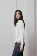 Sweater color crema de punto con cuello redondo y mangas largas con paneles de lentejuelas plateadas.