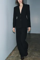 Blazer entallada de Zara Woman Collection, color negro, con cuello solapa de muescas, manga larga con botones en puños y cierre frontal con botones. Presenta bolsillos de vivo en el delantero y detalle de pespuntes marcados a tono.