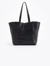 Cartera tipo shopper de cuero vacuno flor graneado, con formato amplio y estructura flexible. Presenta dos cierres verticales decorativos en el frente con tiracierres personalizados y doble manija de hombro.