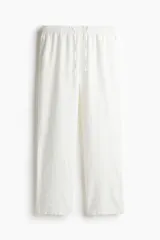 Pantalón de corte relajado, confeccionado en mezcla de lino y viscosa color blanco. Cuenta con elástico revestido y cordón ajustable en la cintura, bolsillos al bies y un bolsillo trasero insertado.