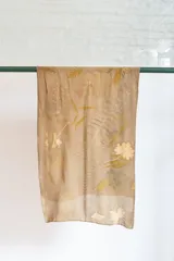 Pañuelo de seda natural color verde romerillo, con impresión botánica de hojas de helecho y malvarrosa.