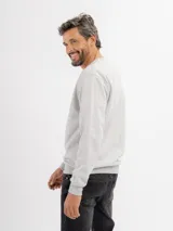 Buzo de felpa color beige, de cuello redondo y mangas largas con puños acanalados.