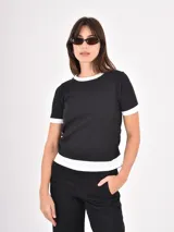 Remera de algodón en color negro con detalles en blanco en el cuello, mangas y ruedo. Presenta un diseño de estilo ringer con terminaciones acanaladas.