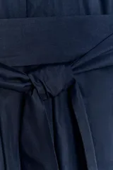 Vestido camisero midi color azul marino, con cuello solapa, escote pico y manga corta con vuelta. Presenta bolsillos laterales ocultos, solapas decorativas en el pecho, cinturón de lazo en el mismo tejido y cierre frontal con botones.