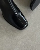 Bota negra de cuero vacuno con taco cuadrado y caña media.