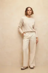 Pantalón negro de vestir, de corte recto y tiro alto, con pinzas y bolsillos laterales.