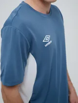 Remera deportiva Umbro modelo Vant, de color negro con paneles laterales grises y cuello redondo, diseñada para hombre.