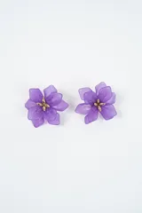 Aros tipo caravana con diseño de flor en color violeta, elaborados en material acrílico con centro decorativo en tono dorado.