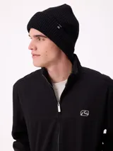 Gorro tipo beanie de punto con textura waffle, color negro, con etiqueta de marca en el lateral.