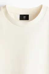 Remera de corte holgado confeccionada en punto interlock de algodón, con cuello redondo acanalado, hombros caídos y bajo recto.