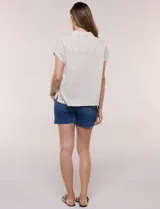 Camisa de lino de estructura recta, color beige con rayas verticales blancas. Cuenta con cuello solapa, escote en V abierto, abotonadura frontal, bolsillo plaqué en el pecho, mangas cortas de hombro caído y ruedo recto.