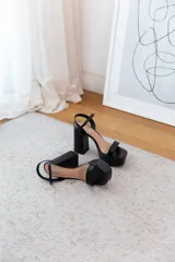 Sandalias de fiesta negras con plataforma y tacón cuadrado. Tira delgada sobre los dedos y tobillo con hebilla ajustable.