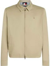 Campera tipo Harrington de algodón color beige claro, con cuello camisero y cierre frontal de cremallera. Presenta bolsillos laterales ribeteados y el logo de Tommy Hilfiger bordado en el pecho.