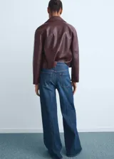 Jeans wide leg tiro alto de denim azul con cinco bolsillos, trabillas para cinto y cierre frontal con cremallera y botón.