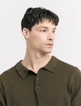 Remera color café de tejido de punto, con cuello polo y mangas cortas.