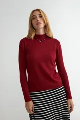 Polera de tejido de punto fino color bordó, con cuello alto y mangas largas.