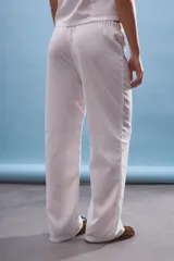 Pantalón blanco de corte ancho y tiro medio/bajo con cordón ajustable en la cintura.