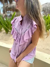 Camisa verde brillante de muselina con volados en el frente y tachas plateadas.