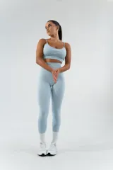 Conjunto deportivo celeste compuesto por un top con tirantes finos y calza larga de cintura alta.