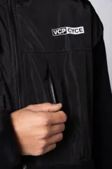 Campera de polar con recortes en tela técnica tipo sire en la parte superior frontal. Presenta cierre frontal completo, cuello alto y bolsillos funcionales en el pecho. Diseño bicolor en tonos verde oliva y negro con logo de la marca en el pecho.