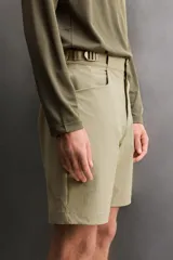 Pantalón corto de estilo técnico, color beige, con ajuste regular. Cuenta con cintura ajustable mediante cinturón de doble hebilla, cierre frontal con cremallera y botón a presión, bolsillos laterales y bolsillos con cremallera oculta.