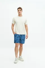 Short de baño de largo medio, con estampado de rayas verticales en tonos celeste y blanco. Posee cintura elástica con cordón de ajuste negro y forro interior amarillo.