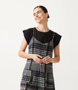 Enterito corto con tirantes finos y estampado a cuadros en tonos blanco, negro, verde y amarillo.
