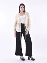 Blusa abierta de textura semitransparente en tono beige, con mangas largas y cordones ajustables en el frente.