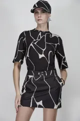 Blusa negra con estampado abstracto en blanco y apliques brillantes.