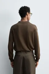 Polo de punto regular fit en color beige, confeccionado con una mezcla de algodón y cáñamo. Presenta cuello solapa con abertura frontal, manga larga y acabados en rib.