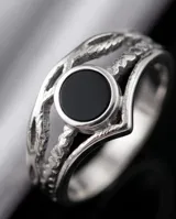Anillo de acero con piedra central de ónix negro y diseño de bandas entrelazadas.