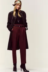 Pantalón de tiro alto y corte tobillero, confeccionado en tejido de aspecto denim oscuro. Presenta diseño de pinzas frontales, bolsillos laterales y cierre frontal con cremallera, botón y gancho. Incluye un cinturón fino a tono con hebilla metálica dorada.