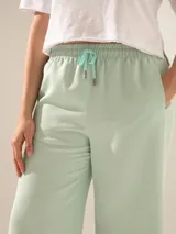 Pantalón de pata ancha color verde agua, con elástico en la cintura y cinta hilera a tono.