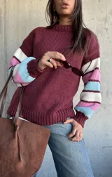 Sweater de tejido de punto con cuello redondo, cuerpo en color bordeaux y mangas con diseño de rayas horizontales en tonos bordeaux, blanco, rosado y celeste.