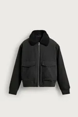 Cazadora bomber cropped fit de algodón color negro, con cuello solapa de borreguillo a contraste, bolsillos frontales con solapa y cierre de cremallera.
