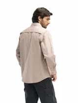 Camisa de manga larga azul marino, con cuello abotonado, cierre frontal con botones, dos bolsillos frontales con tapa y botón, puños con botón y opción de arremangado.