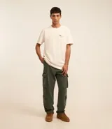 Pantalón baggy color verde militar, confeccionado en sarga de algodón, con cintura con trabillas, cierre con botón y cremallera, y bolsillos cargo laterales. Modelo holgado de estilo vintage.