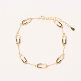 Pulsera dorada con eslabones ovalados intercalados, algunos de ellos adornados con pequeños cristales. Cuenta con cierre de mosquetón y cadena de extensión.