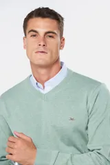 Suéter de tejido fino color azul marino, con cuello en V y manga larga. Presenta un pequeño logo bordado en el pecho.