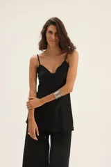 Musculosa negra de seda con escote en V y detalle de flecos en el escote.