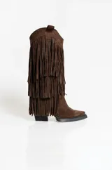 Botas texanas de gamuza color marrón, con diseño de caña alta adornada con múltiples capas de flecos. Presentan taco cuadrado y punta ligeramente afinada.