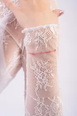 Remera de encaje bordó con transparencias, diseño de cuello alto y mangas largas. Confeccionada en tejido de red con motivos florales.
